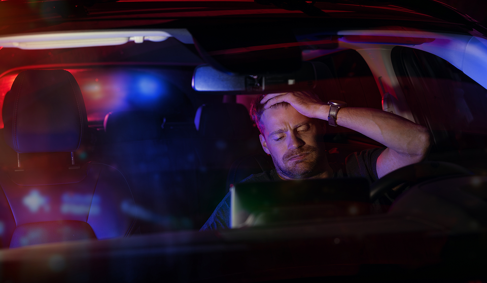 stressed man pulled over with police lights in back window