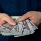 guy holding hundred dollar bills