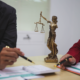 lady justice statue with people are crunching numbers