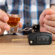 guy in handcuffs holding a shot next to car keys